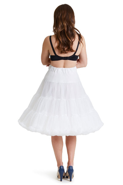 Woman wears white knee length petticoat, with black accessories, back view