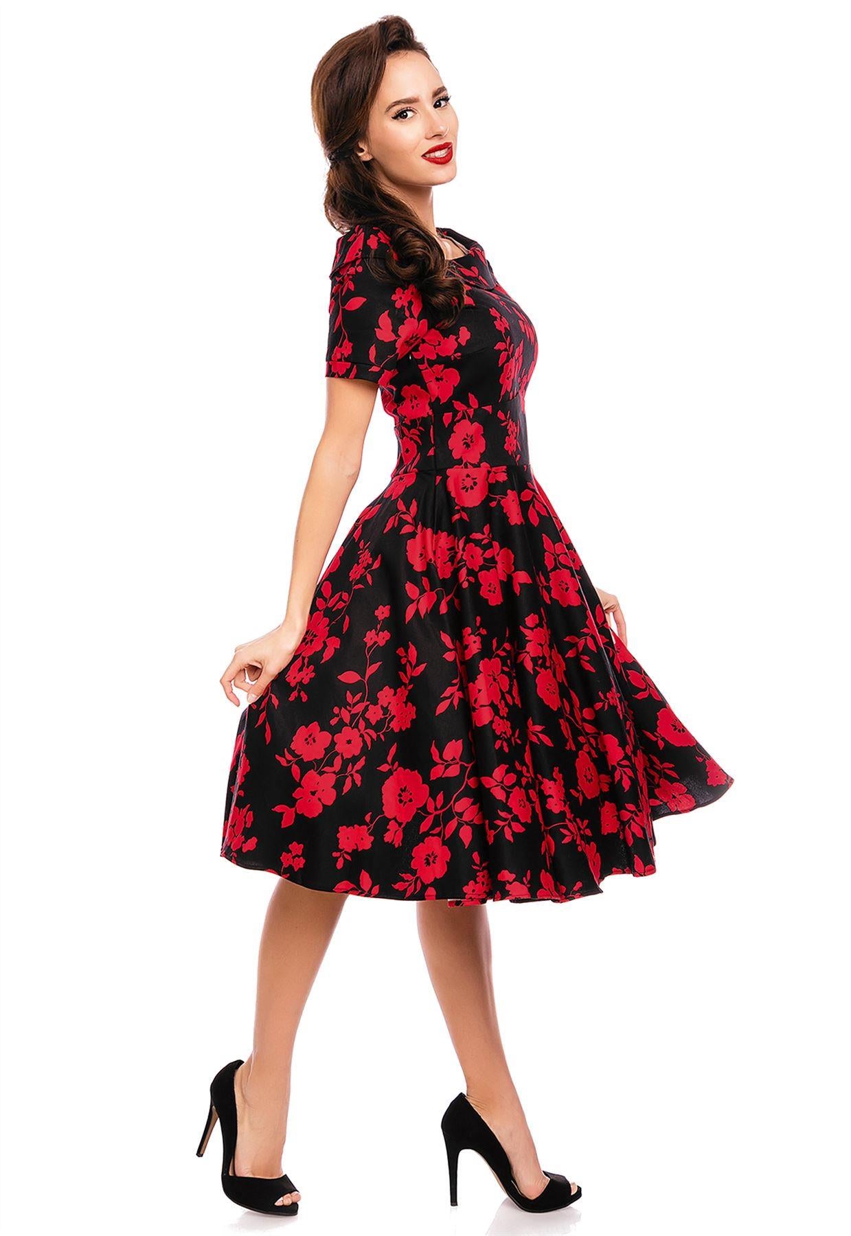 Model wearing our bateau neckline Darlene dress, in black/red floral print, side view