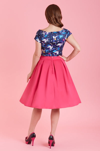 Model wears our V neck, short sleeve top, in unicorn space rainbow print, with a pink skirt, back view