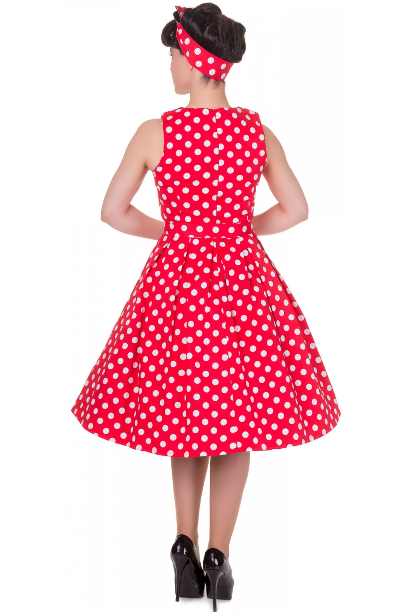Model wearing our sleeveless Annie dress, in red, with white spots, back view