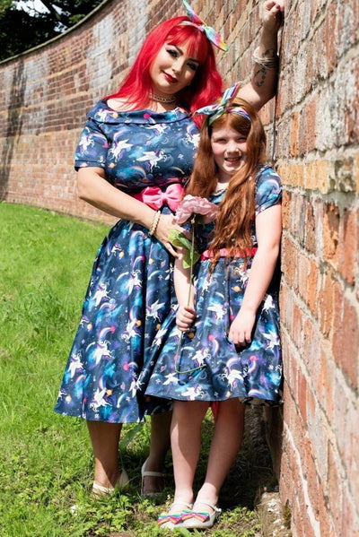Girl wears our short sleeved swing dress, in navy blue unicorn, space rainbow print, with her mother, in matching mini me dress