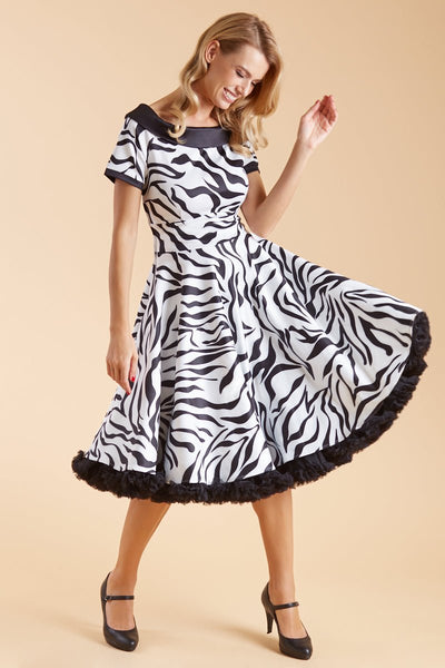 Model wears our short sleeve flared dress, in white and black zebra print, with a black petticoat, front view
