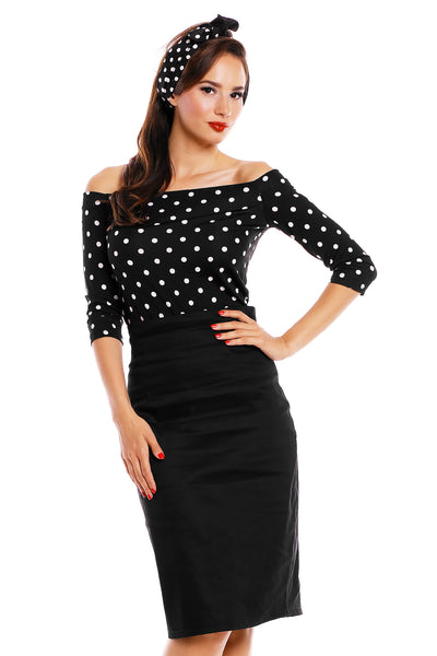 Model wearing our Gloria off-shoulder Top in Black/White polka dot print, with matching headband and skirt front view