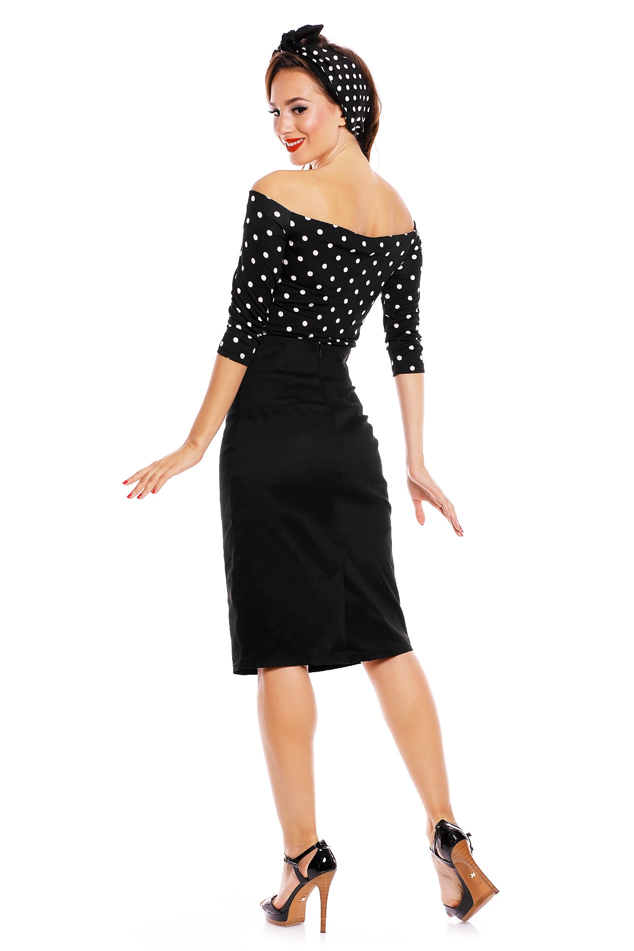 Model wearing our Gloria off-shoulder Top in Black/White polka dot print, with matching headband and skirt back view