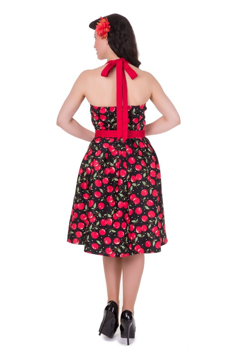 Model wearing halterneck cherry print dress in black and red back view