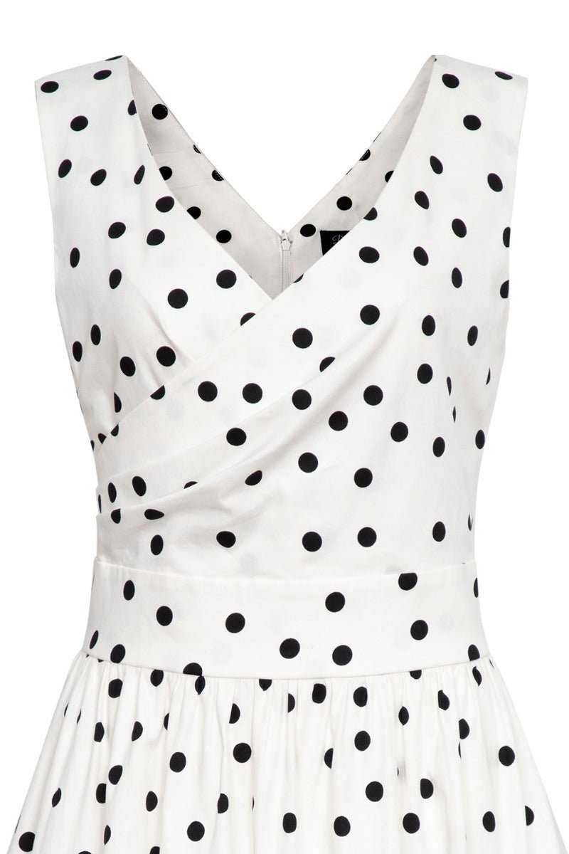 White wrap bust dress with black polka dots close up