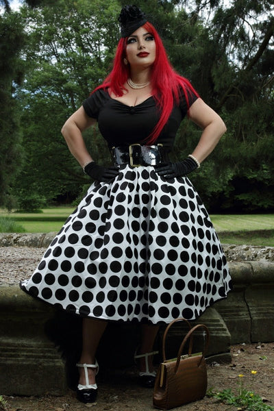 Influencer wearing black and white spot fit and flare dress