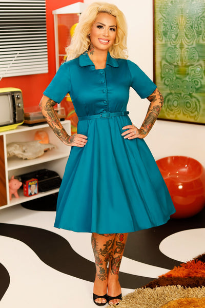 A model wearing a 1950's Teal Blue Shirt Dress