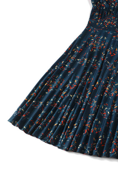 Skirt view of short sleeved blue midi dress, with red chili print