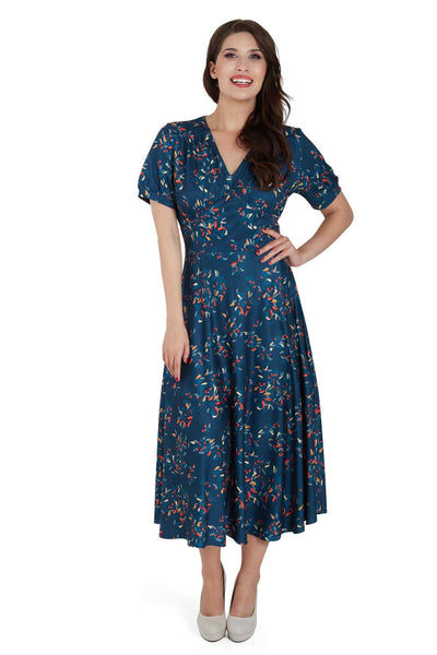 Front view of woman wearing our short sleeved blue midi dress, with red chili print