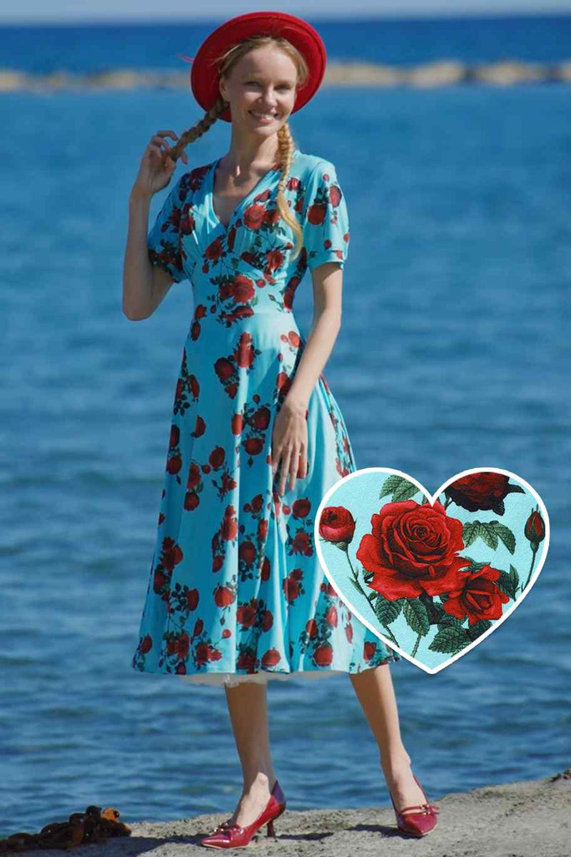 A lady wearing a 50s Style Red Rose Sleeved Dress in Blue