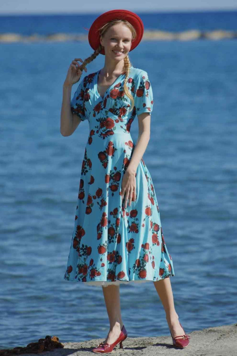 A lady wearing a 50s Style Red Rose Sleeved Dress in Blue