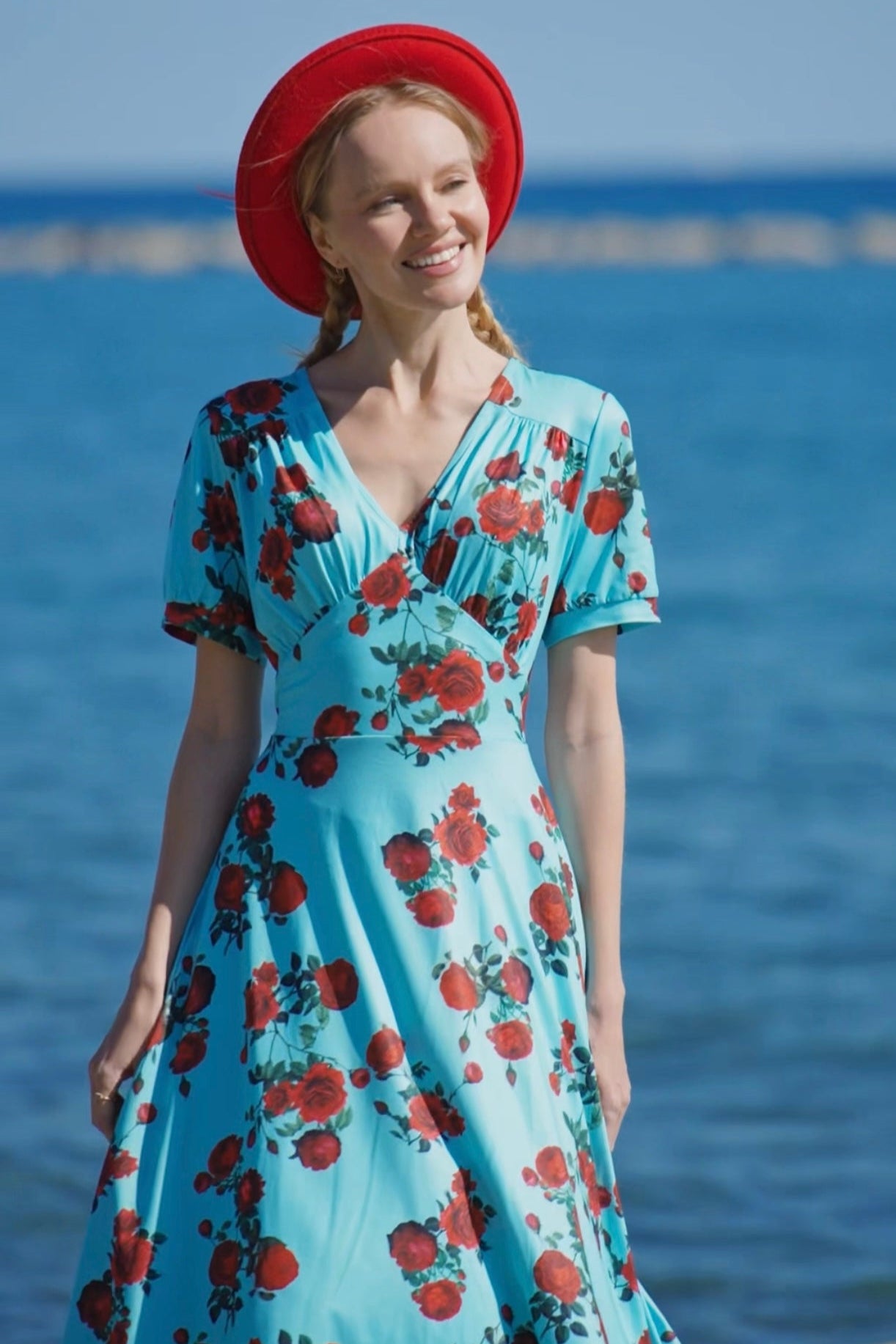 A lady wearing a 50s Style Red Rose Sleeved Dress in Blue
