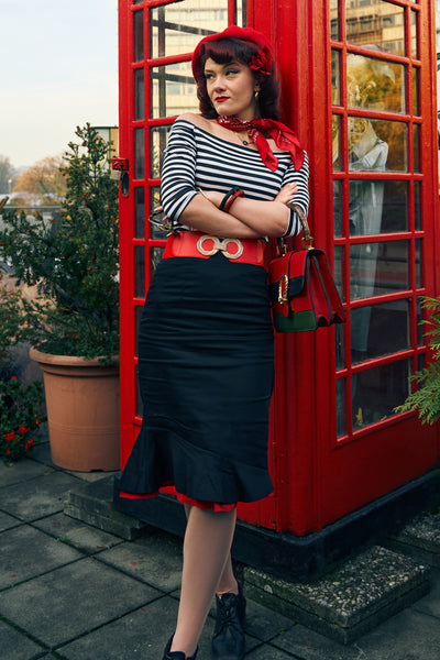 A model wearing an Off Shoulder Retro Striped Top in Black and a High Waist 50s Style Ruffle Skirt In Black & Red
