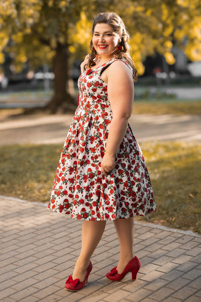 A woman wearing an Amanda Retro Red Roses Swing Dress In White