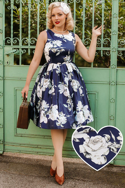 A lady wearing a Retro White Navy Rose Swing Dress