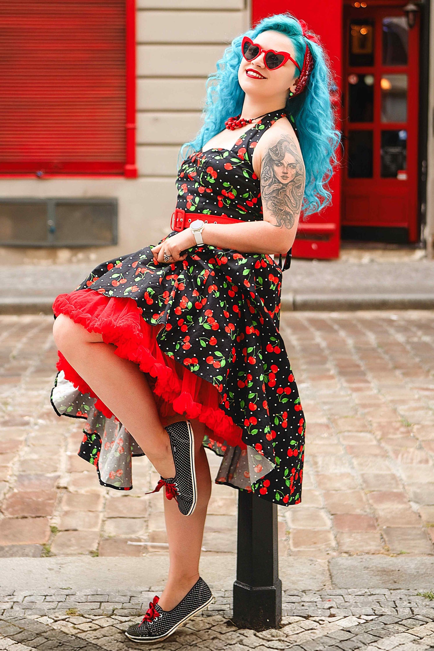 A lady wearing a Daisy Red Cherry Halter Dress In Black