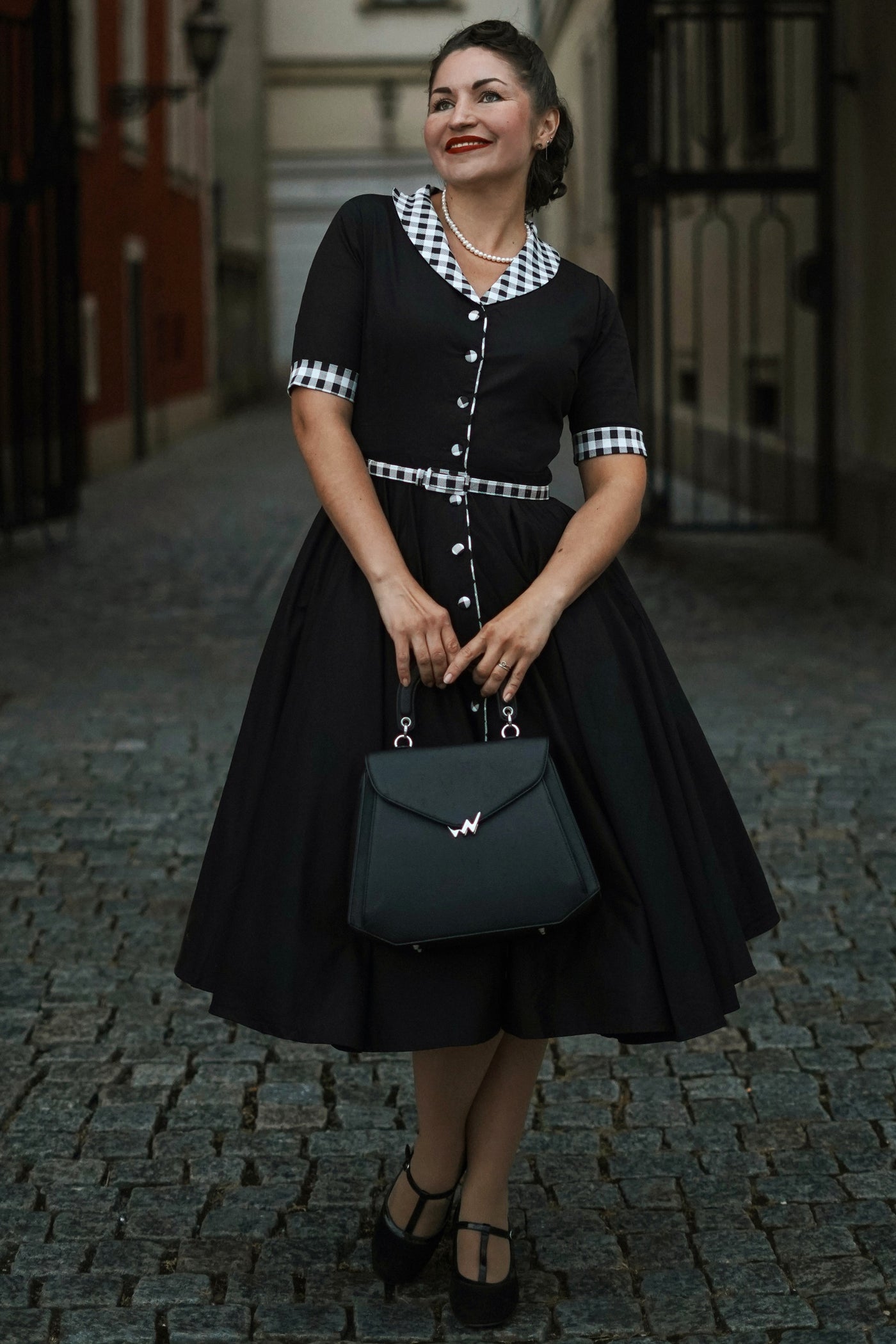 A woman wearing a Mollie Black Full Circle Shirt Dress With Gingham