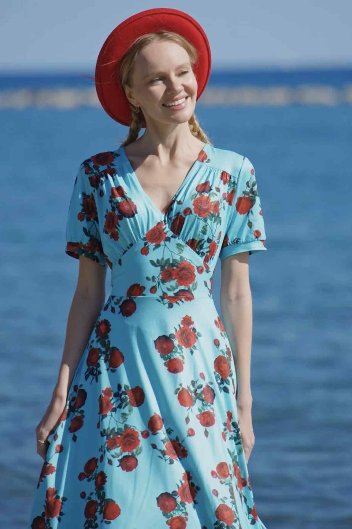 A lady wearing a 50s Style Red Rose Sleeved Dress in Blue