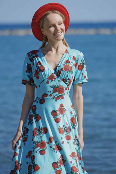 A lady wearing a 50s Style Red Rose Sleeved Dress in Blue