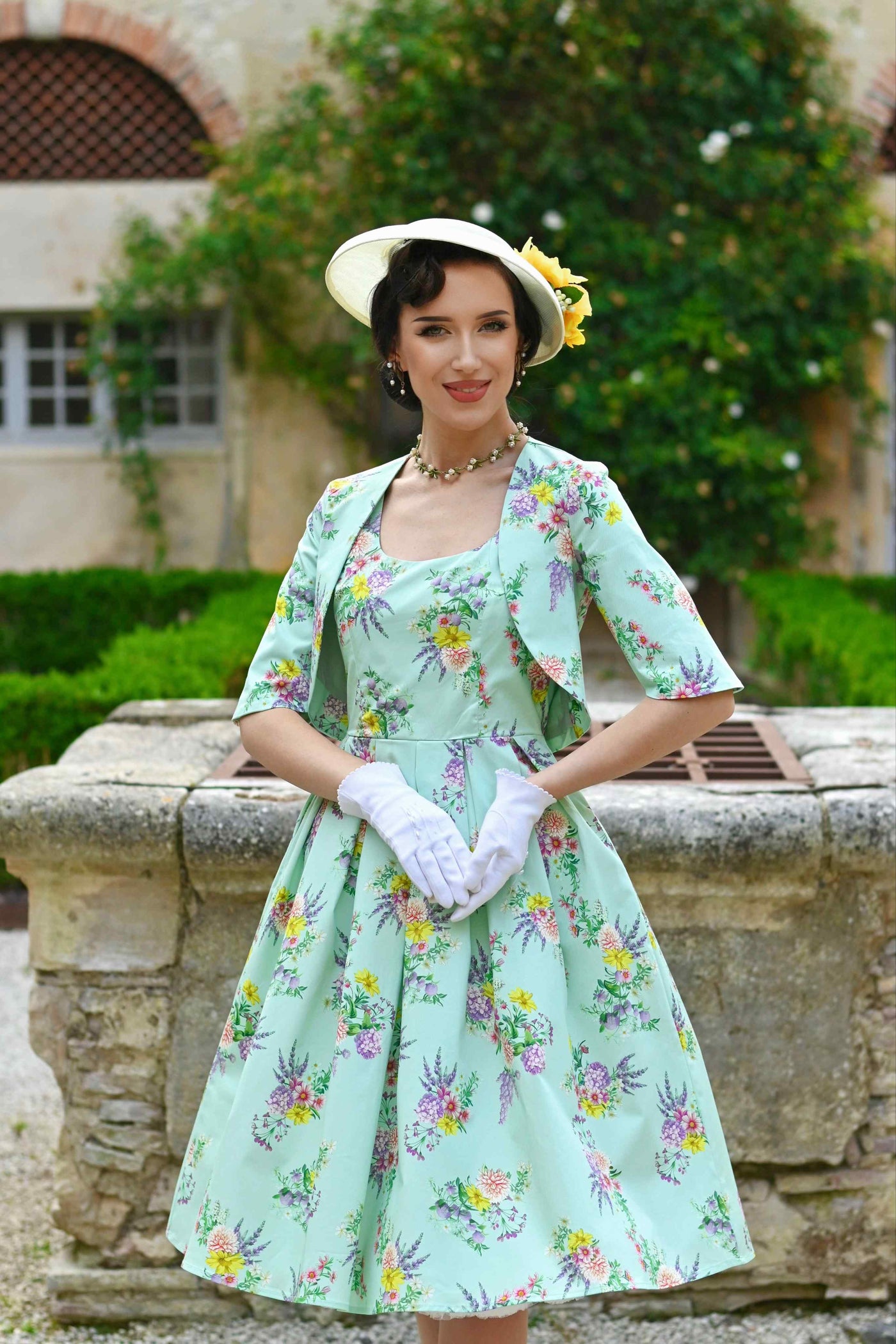 Model wearing Amanda Pastel Floral Swing Dress In Light Green with a jacket