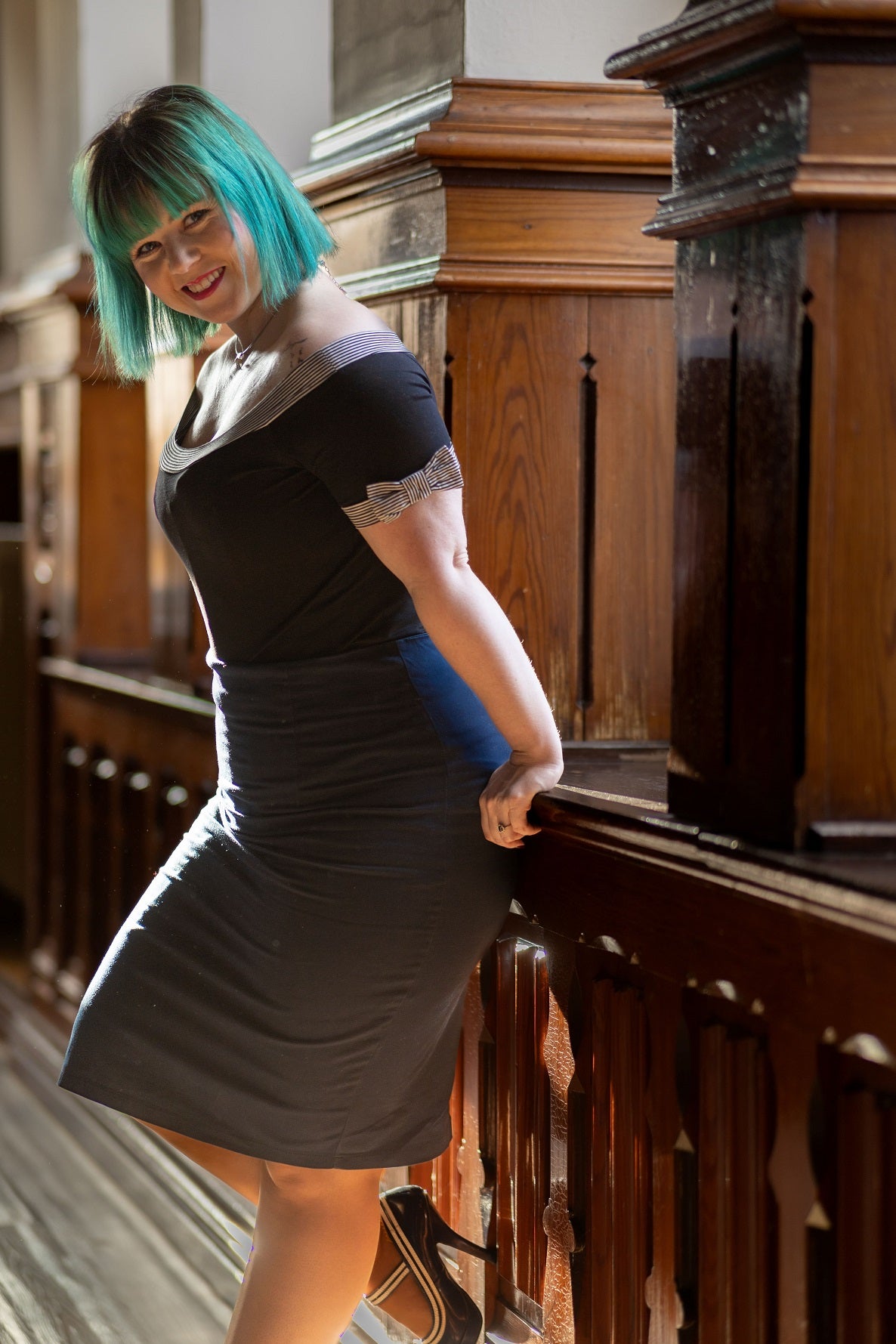 Customer wears our short sleeved round neck top, in black, with stripe trims, side view
