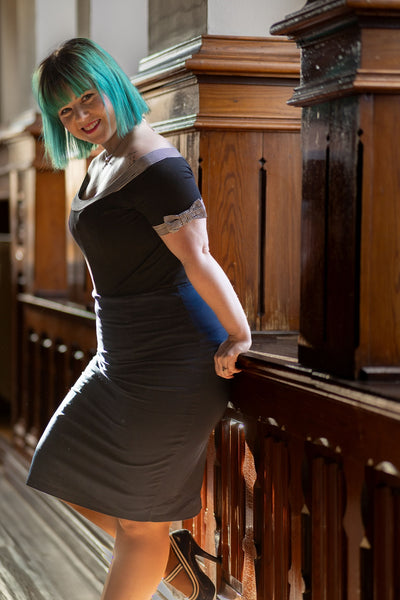 Customer wears our short sleeved round neck top, in black, with stripe trims, side view