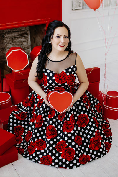 A model wearing an Elizabeth Vintage Style Polka Roses Party Dress in Black-Red