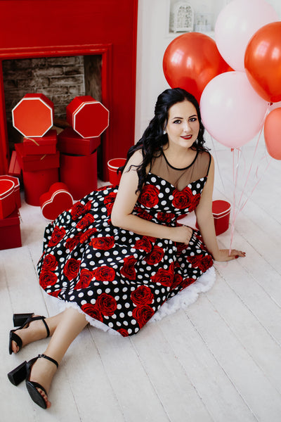 A model wearing an Elizabeth Vintage Style Polka Roses Party Dress in Black-Red