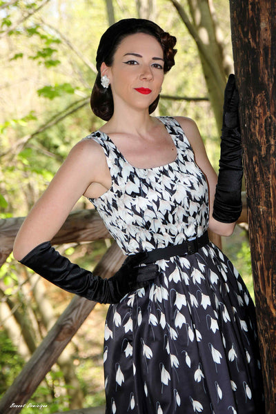 A model wearing a Amanda 50s Inspired Black Swing Dress & Snowdrops
