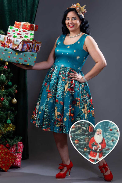 A model wearing an Amanda Santa Is Back In Town Dress In Teal Blue