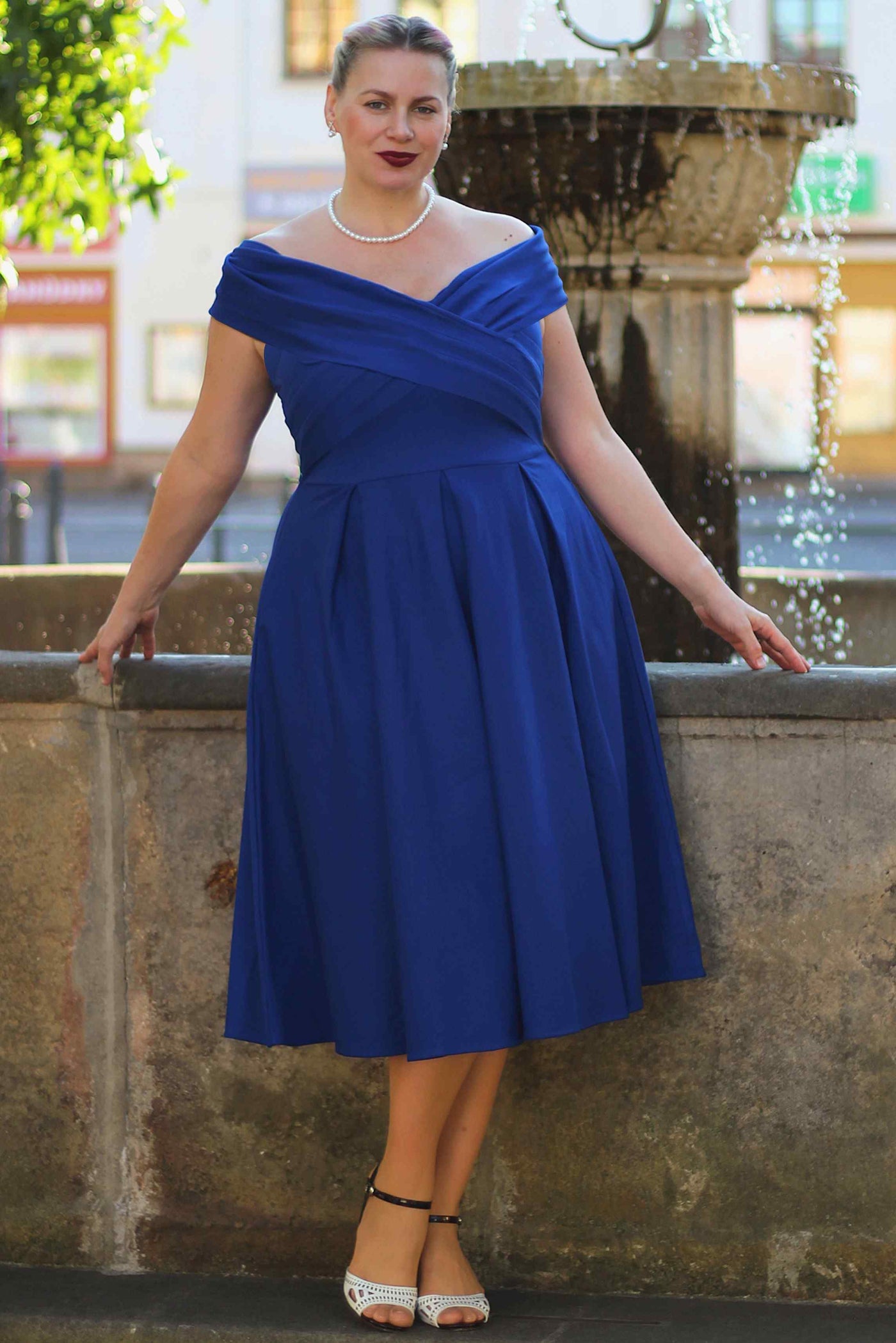 A model wearing a Beverly Royal Blue Off Shoulder Dress
