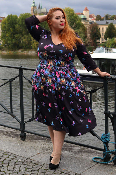 A lady wearing a Billie Black Butterfly Long Sleeved Dress