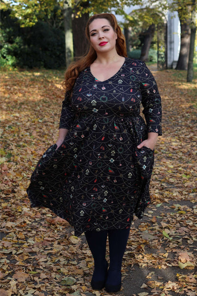 A woman wearing a Billie Christmas Print Long Sleeved Dress