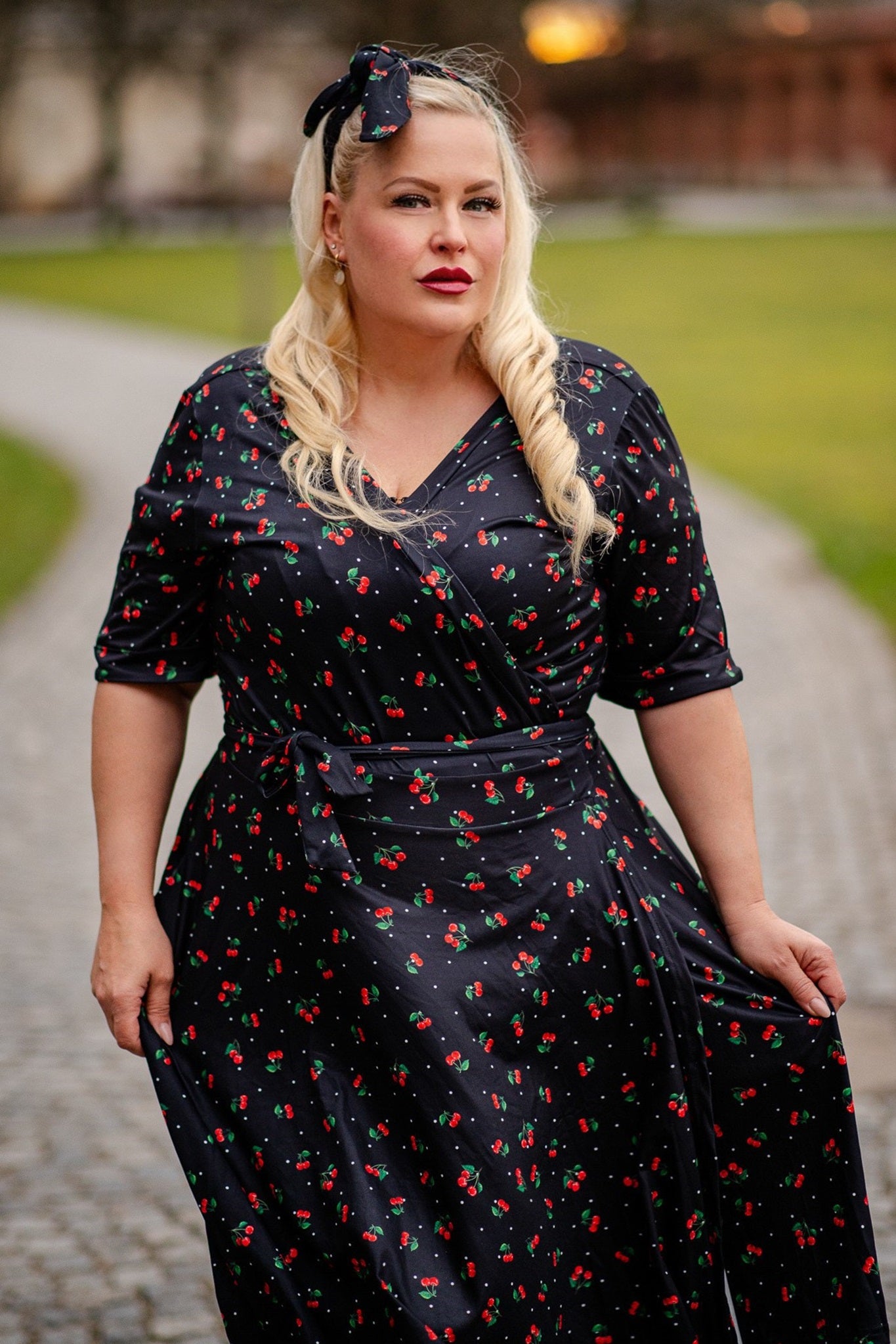 Customer wears our Matilda short sleeved wrap dress in black, with red cherries print