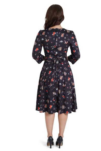 Model wears our long sleeved, flared dress, in black, classic tattoos print, back view