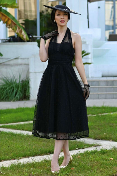 A lovely model wearing a Dorothea Black Polka Dot Mesh Halter Dress
