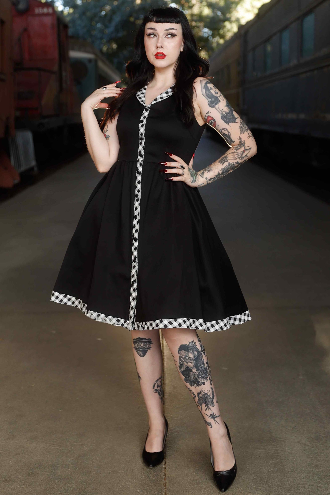 A model wearing Black Sleeveless Shirt Dress With Gingham Stripes