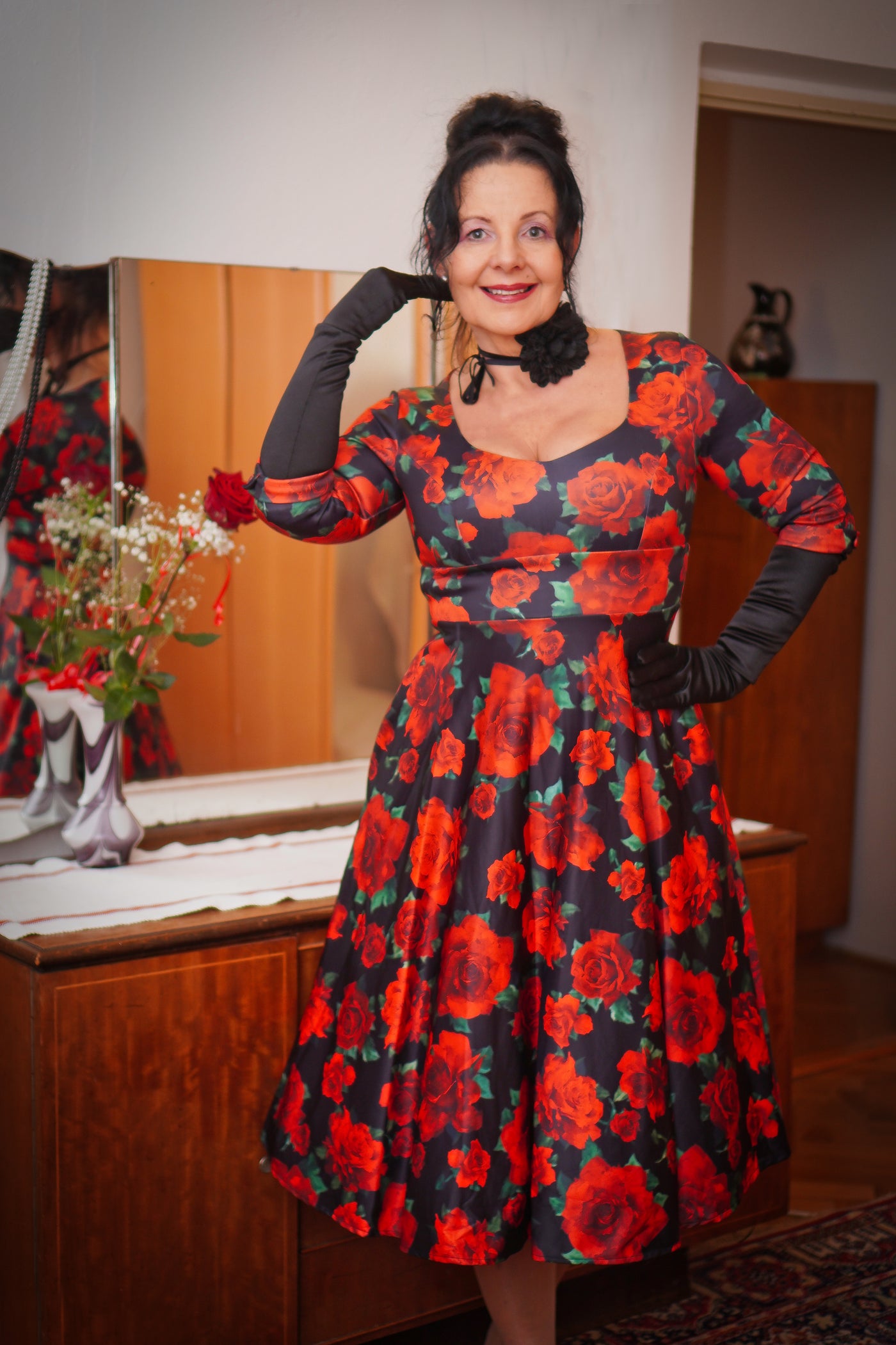 Woman wears our long sleeved midi dress, in black and red floral print