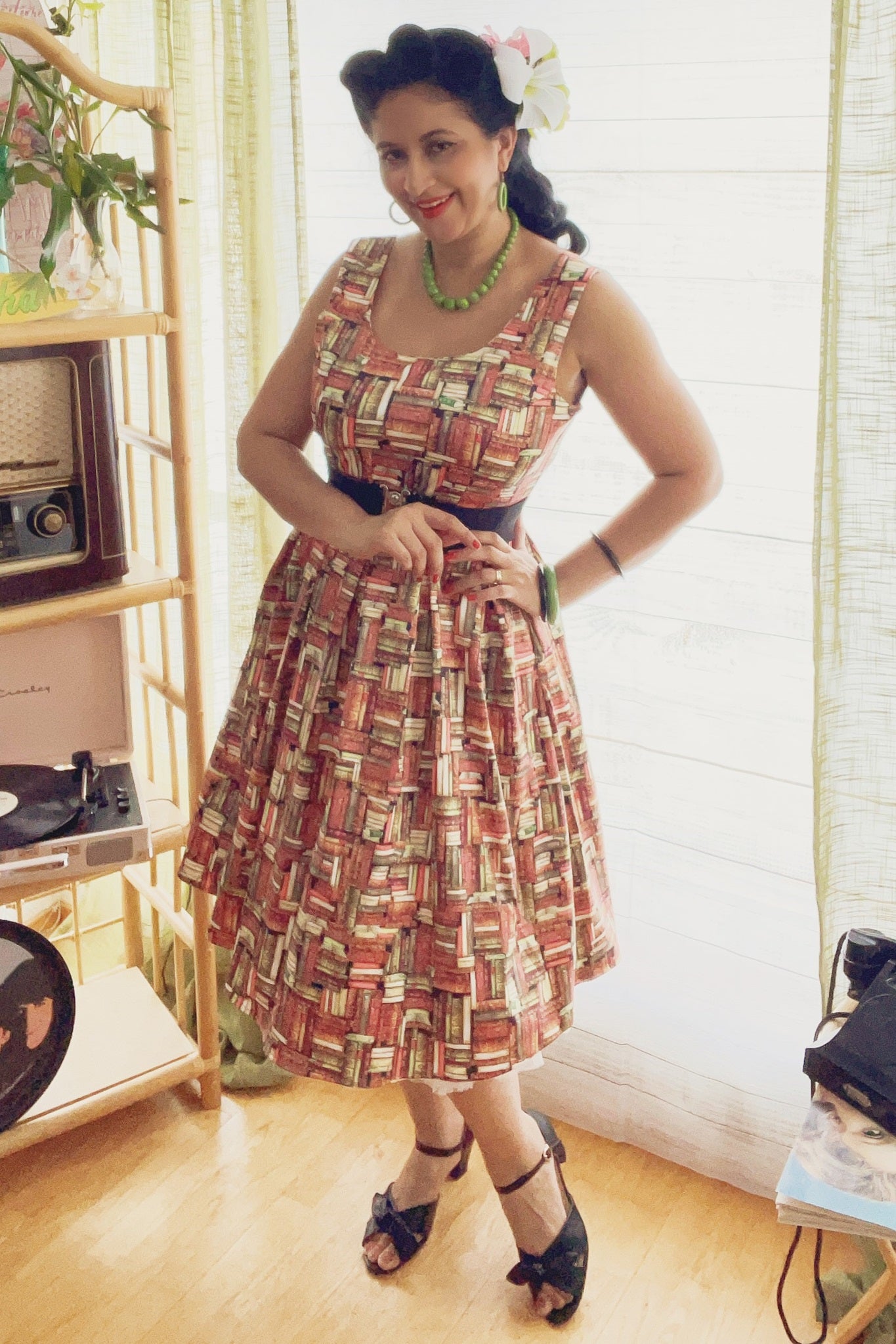 Customer wears our sleeveless swing dress, in library book print, with vintage technology around