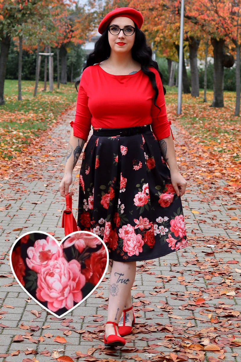 A model wearing Box Pleat Skirt In Black with Raising Red Roses