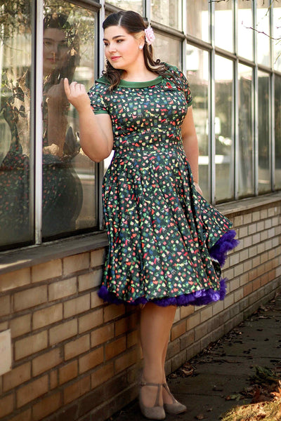 A lady wearing a Cat & Plant Dress In Dark Green