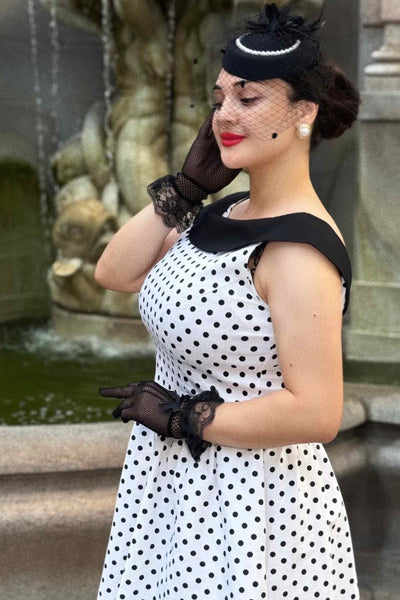 A lady wearing a Cindy White & Black Polka Dot Circle Dress