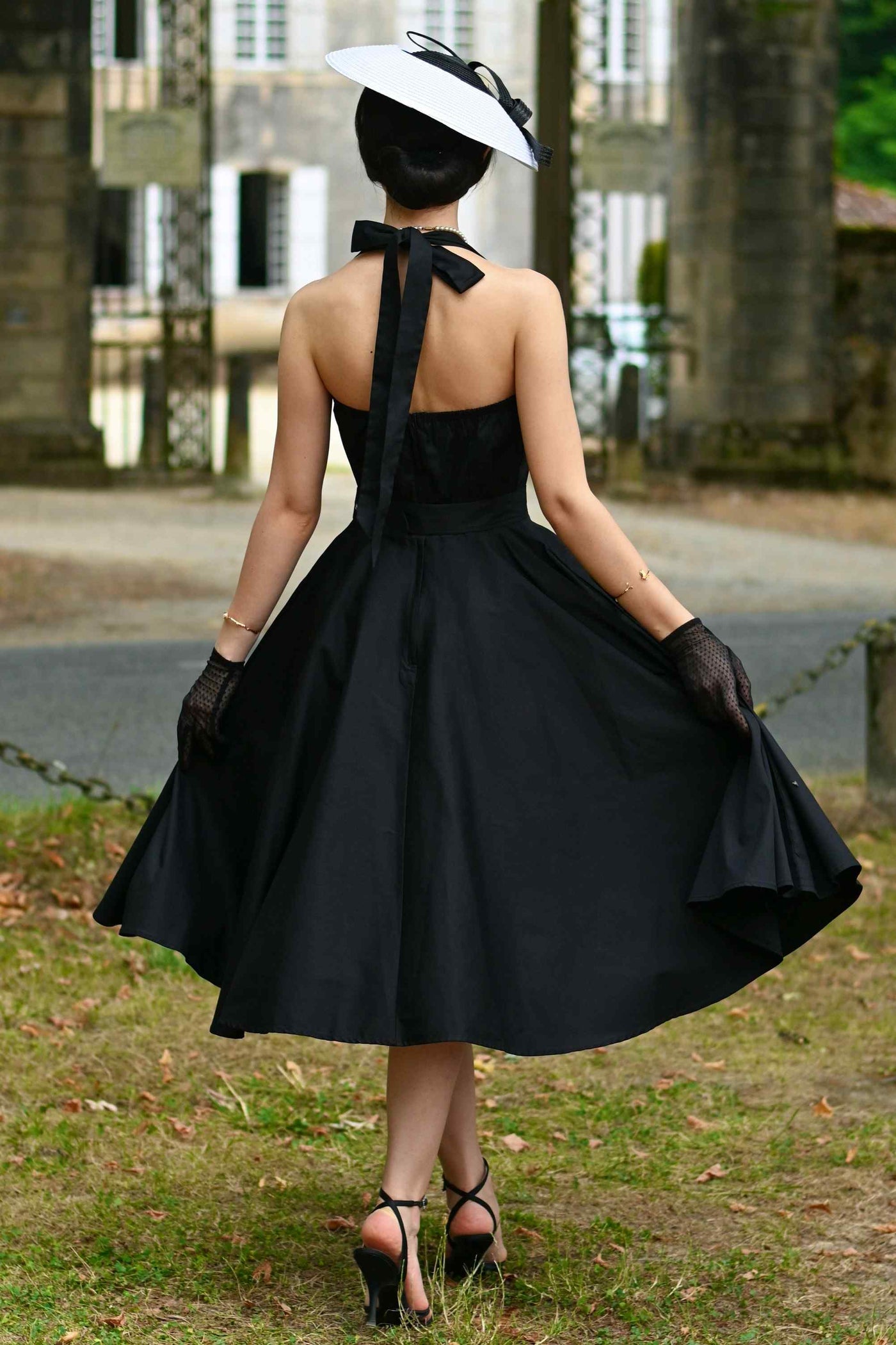 A photo of a model wearing a Daisy Classic Black Halter Dress