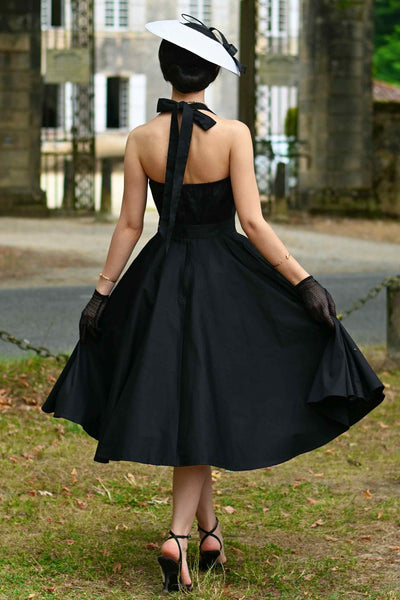 A photo of a model wearing a Daisy Classic Black Halter Dress