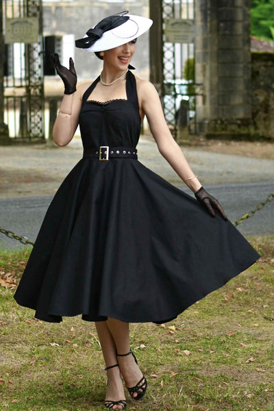 A lady wearing a Daisy Classic Black Halter Dress