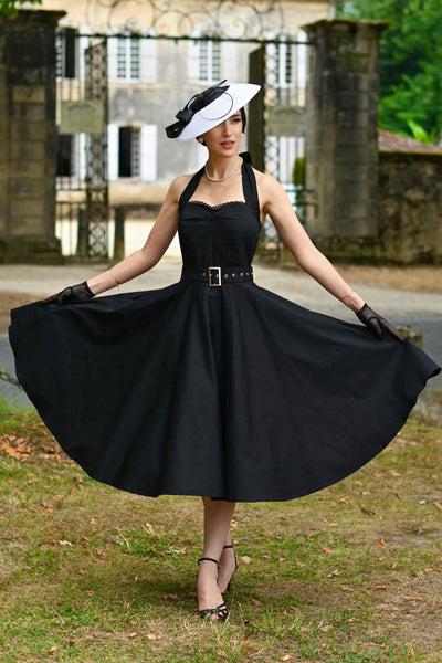 A lady wearing a Daisy Classic Black Halter Dress