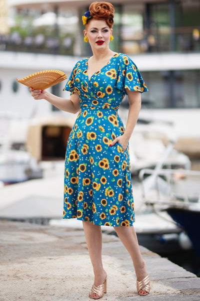 A lady wearing a Crossover Bust Blue Sunflower Dress