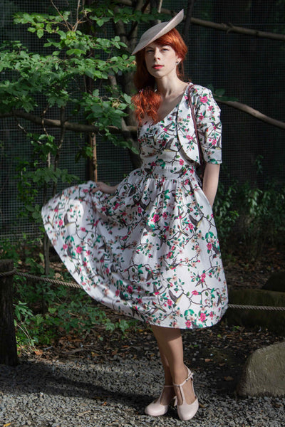 A lovely model wearing a May Crossover Bust Circle Dress In White Bird Print