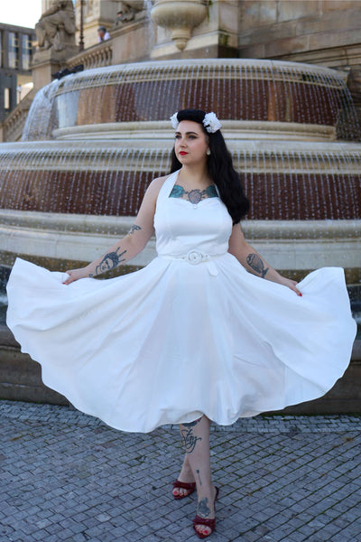 A lady wearing a Daisy White Satin Halter Dress